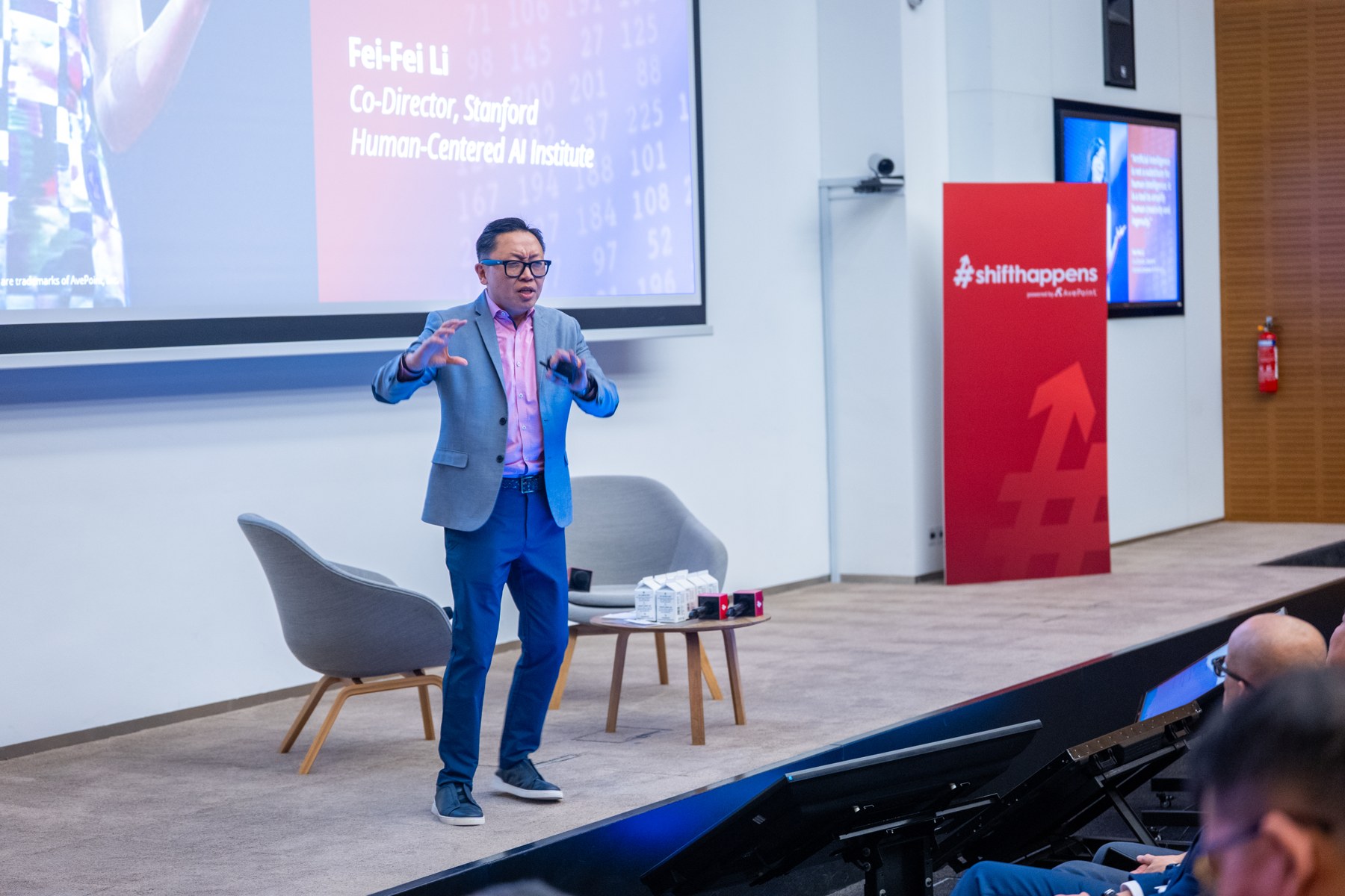 Dux speaking on stage to an audience at a professional event